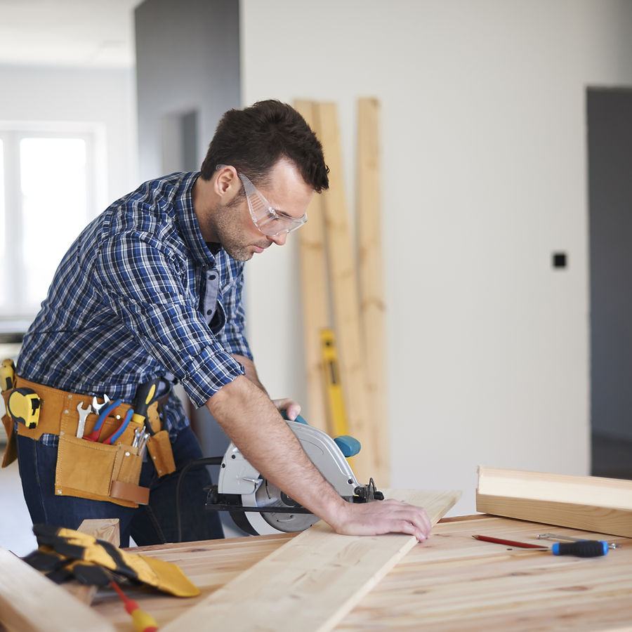 Carpenter cutting timber on a Berm Inc. construction site