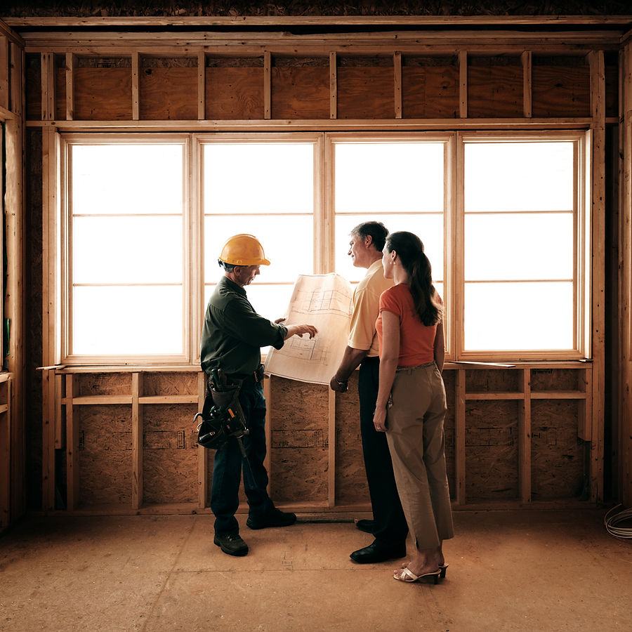 Contractor reviewing blueprints with homeowners — verification starts on paper